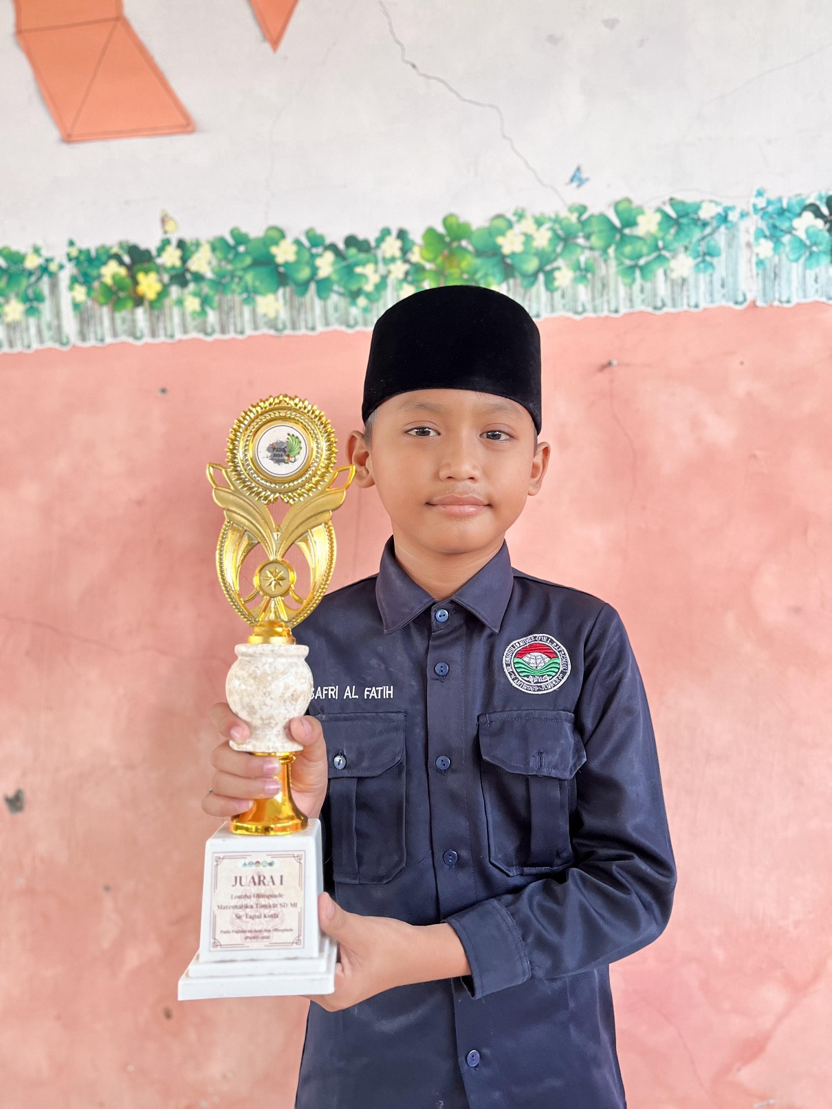 MEMBANGGAKAN: Muhammad Safri Alfatih, santri MI Unggulan Nuris Jember, membawa pulang piala olimpiade matematika se-Tapal Kuda, baru-baru ini. (Nuris Jember)