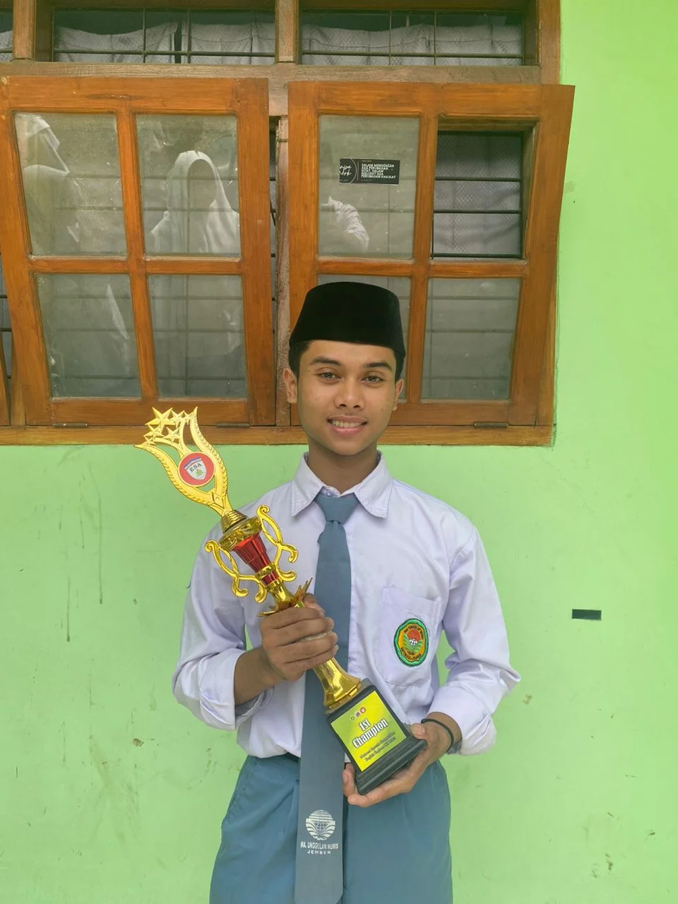 SEMANGAT BERDAKWAH: Siswa MA Unggulan Nuris Jember, Muhammad Helmi Fauzan Kamil, menerima piala sebagai juara satu dai nasional dalam Forcemi Islamic Competition pada 5 Mei lalu. (Nuris Jember)