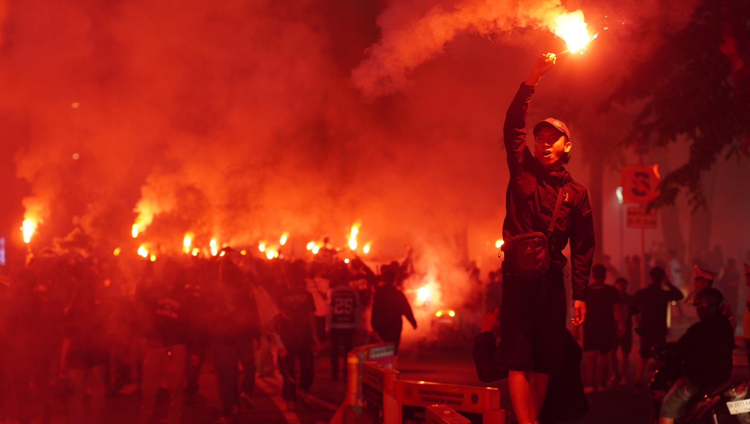 MEMBARA: Suporter Persid Jember South Sector merayakan hari ulang tahun Persid Jember dengan menyalakan flare di Alun-alun Jember. (YULIO FA/RADAR JEMBER)