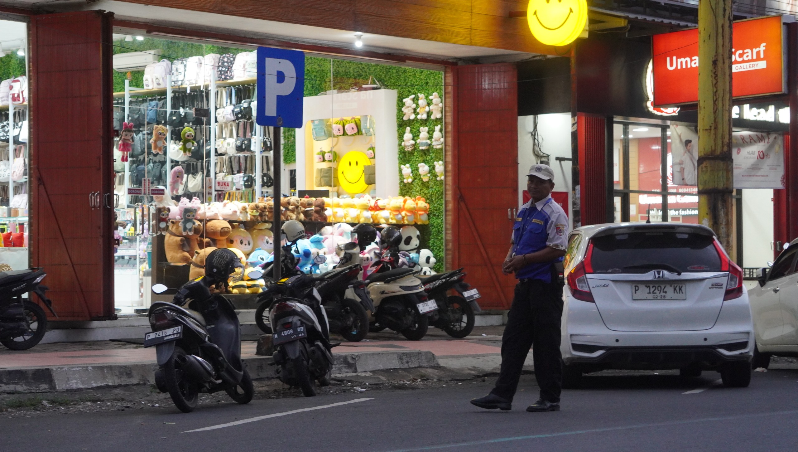 BERTUGAS: Juru parkir Pemkab Jember menjaga kendaraan yang sedang parkir di depan pertokoan Jalan Trunojoyo Kelurahan Kepatihan Kecamatan Kaliwates, Jember, Kamis (22/5). (YULIO FA/RADAR JEMBER)