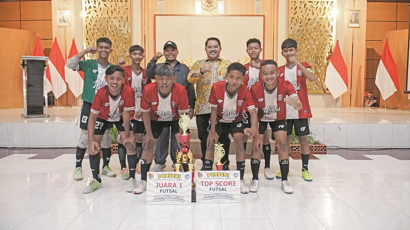 BANGGA: Tim Futsal SMP Nuris Jember dengan trofi juara satu dan top skor dalam Porseni yang diselenggarakan MKKS SMP Swasta Sub-Kota Jember, 19 sampai 21 Mei lalu. (Nuris Jember)