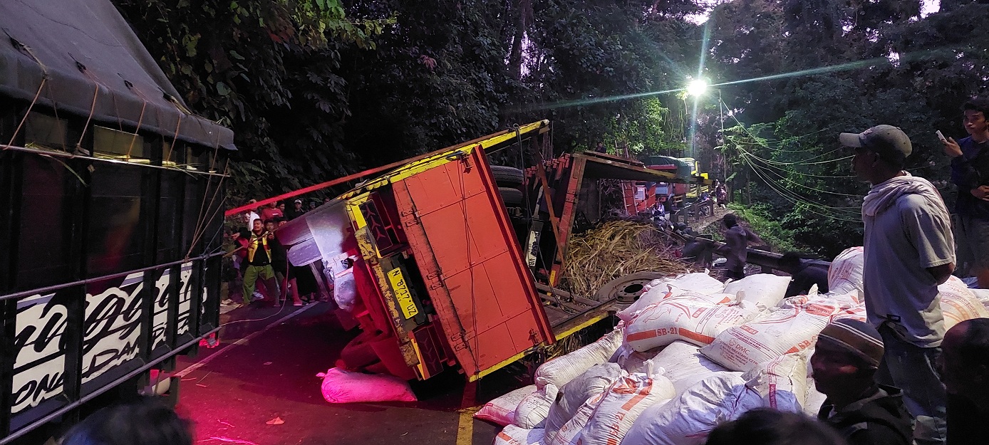 BLACKSPOT: Dua truk terguling di tikungan Mbah Singo, Km 36.800, Dusun Gumitir, Desa Sidomulyo, Kecamatan Silo, mengakibatkan Jalur Gumitir macet total, Senin (26/5). (JUMAI/RADAR JEMBER)