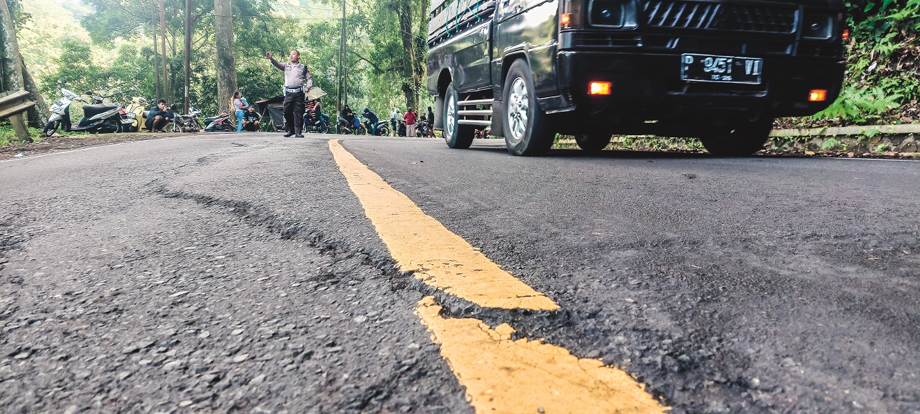 TERLIHAT JELAS: Retakan di tikungan Mbah Singo, Km 36.800 Dusun Gumitir, Desa Sidomulyo, Kecamatan Silo, semakin parah. (JUMAI/RADAR JEMBER)