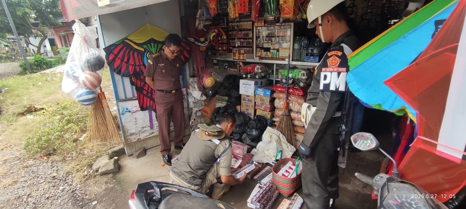 Petugas saat mengamankan rokok ilegal tanpa cukai, di salah satu warung atau toko kelontong warga di Jember, Selasa (27/5/2025). (Satpol PP Jember)