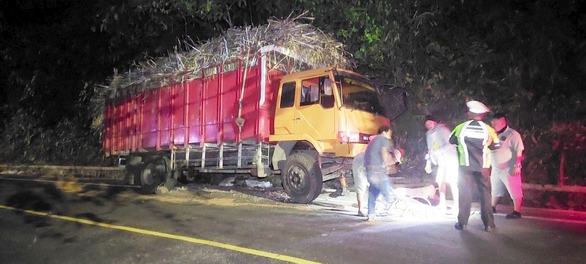 TERPEROSOK: Truk Fuso muatan tebu terperosok di selokan hindari jalan miring di tikungan Mbah Singo KM 36.800, Dusun Gumitir, Desa Sidomulyo, Kecamatan Silo, Selasa (27/5/2025) pukul 16.00. (JUMAI/RJ)
