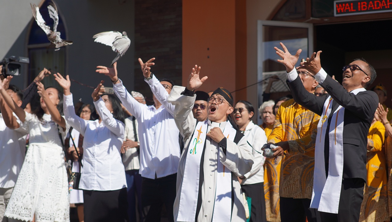 KOMPAK: Ketua GKJW Jember Pendeta Soni Saksono Putro memimpin pelepasan burung dara sebagai simbol pembukaan bulan kesaksian pelayanan usai ibadah Kenaikan Yesus Kristus. (MEGA SILVIA/RADAR JEMBER)