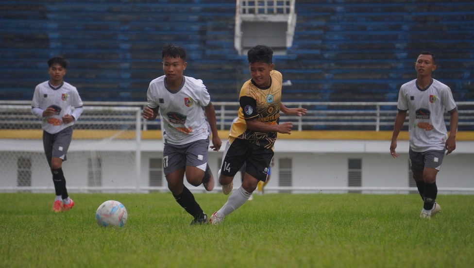 LOLOS: Pesepak bola Porprov Jember (kanan) mencoba melewati pemain Porprov Lumajang di babak Pra-Porprov, (27/5/2025) di Stadion JSG. (YULIO FA/RADAR JEMBER)