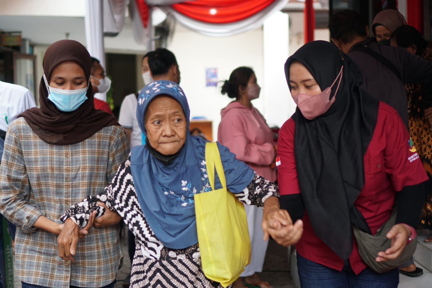 Pagawai Kementerian Sosial (Kemensos) membantu salah seorang lansia. (Kemensos)