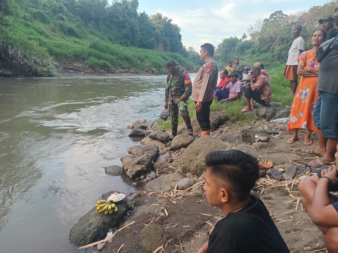 TERUS DIPANTAU: Sejumlah polisi dibantu warga ketika masih memantau aliran sungai Sampean Baru mencari salah seorang warga yang hanyut.