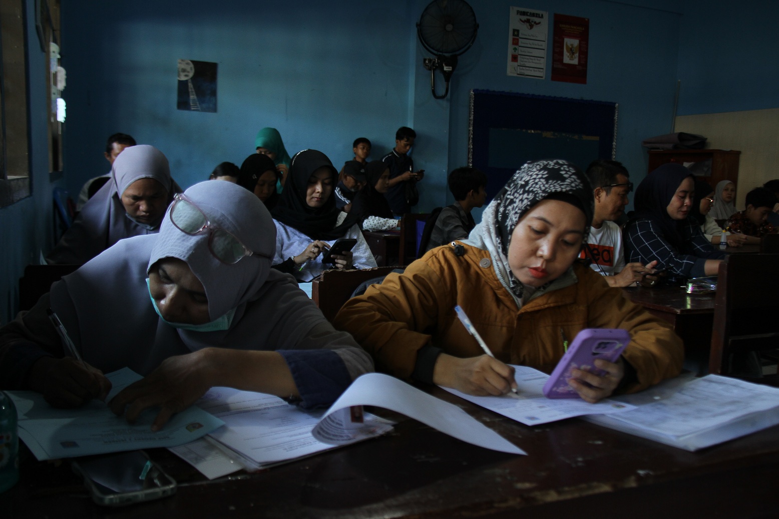 SIBUK: Ibu-ibu terpantau banyak yang mendampingi putra-putrinya saat mendaftar di sekolah yang dituju, seperti saat SPMB di SMPN 2 Jember, Selasa (10/6). (JUMAI/RADAR JEMBER)