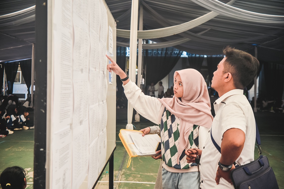 CARI NAMA: Kikandrya Adia Fathina melihat hasil SPMB tahap pertama di SMPN 2 Jember, kemarin (16/6).