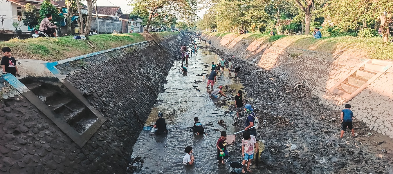 SERU: Warga dari mulai orang dewasa hingga anak-anak rela bermain lumpur demi mencari ikan.