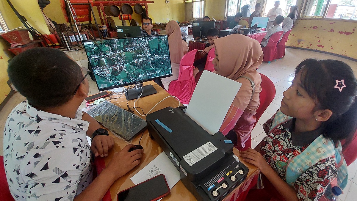 CEK LANGSUNG: Calon siswa dan orang tuanya langsung menyaksikan jarak dari rumah dengan sekolah, saat daftar SPMB jalur domisili, di SMPN 1 Ambulu, kemarin (24/6/2025).