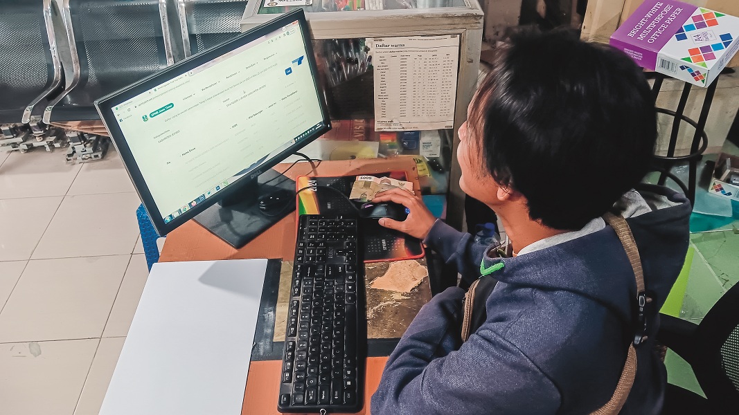 MEMANTAU: Nur Fuad salah satu wali murid menanti pembukaan pendaftaran SPMB jalur domisili, kemarin (25/6/2025).
