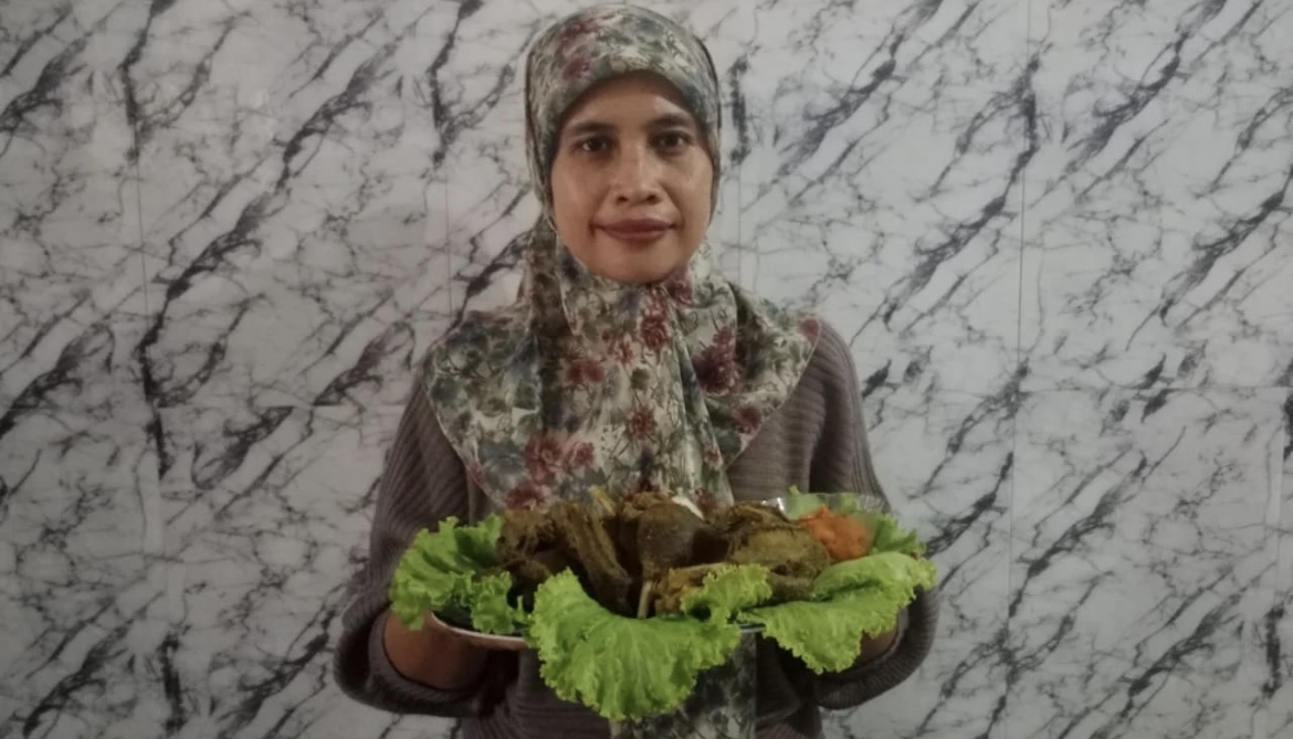SIAP SAJI: Nuraini saat menampilkan bebek ungkep andalannya untuk disajikan kepada pembeli. (FAQIH HUMAINI/RADAR IJEN)
