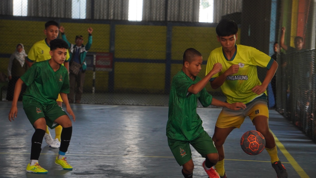 REBUT BOLA: Pemain futsal Jember (gelap) berusaha berebut bola dalam laga final futsal Porseni di lapangan Zona Futsal, Kecamatan Sumbersari, kemarin (9/7/2025).