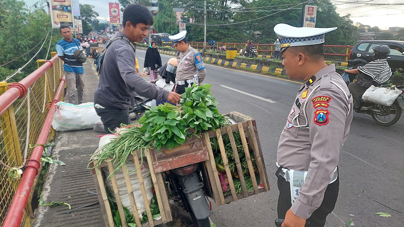 AYO YANG TERTIB: Anggota Satlantas Polres Jember memperingatkan PKL yang berjualan di trotoar Jembatan Gladak Kembar, karena kondisi jalan sudah mulai dipadati kendaraan, kemarin (10/7/2025).