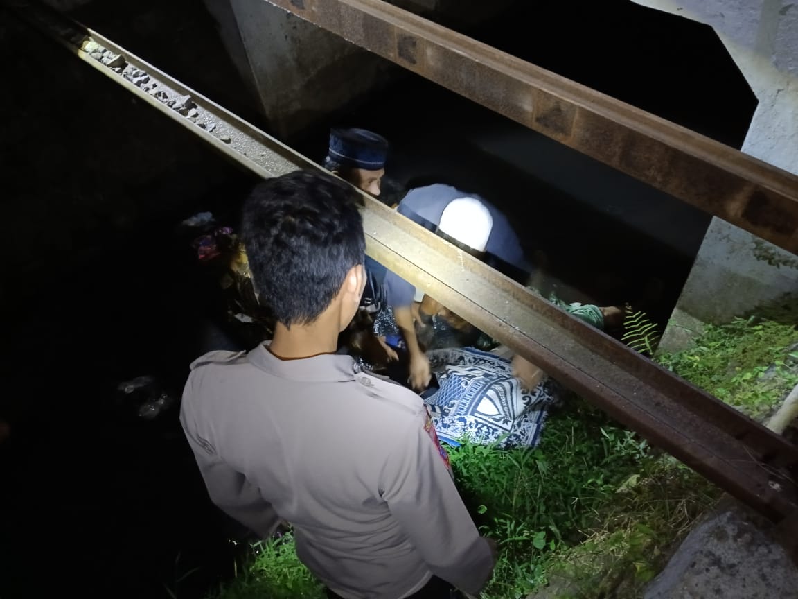 EVAKUASI: Petugas bersama warga mengevakuasi jenazah M Dofir, warga Desa Tisnogambar, Kecamatan Bangsalsari seusai tersambar KA Ijen Ekspres, di Dusun Tegalgebang, Desa Langkap, Kecamatan Bangsalsari,
