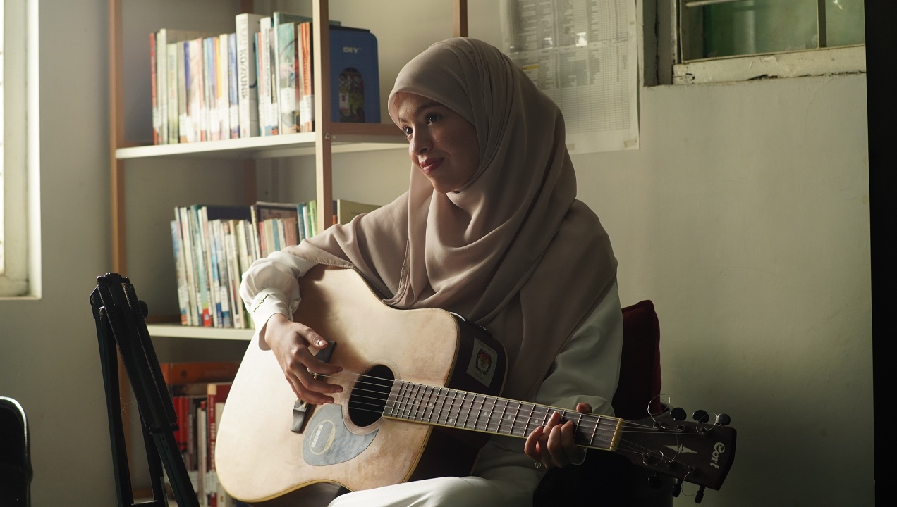 GENJRENG GITAR: Mahasiswa asal Aljazair, Aya Bentabi, menunjukkan kemampuannya bermain gitar di Universitas Islam Jember.