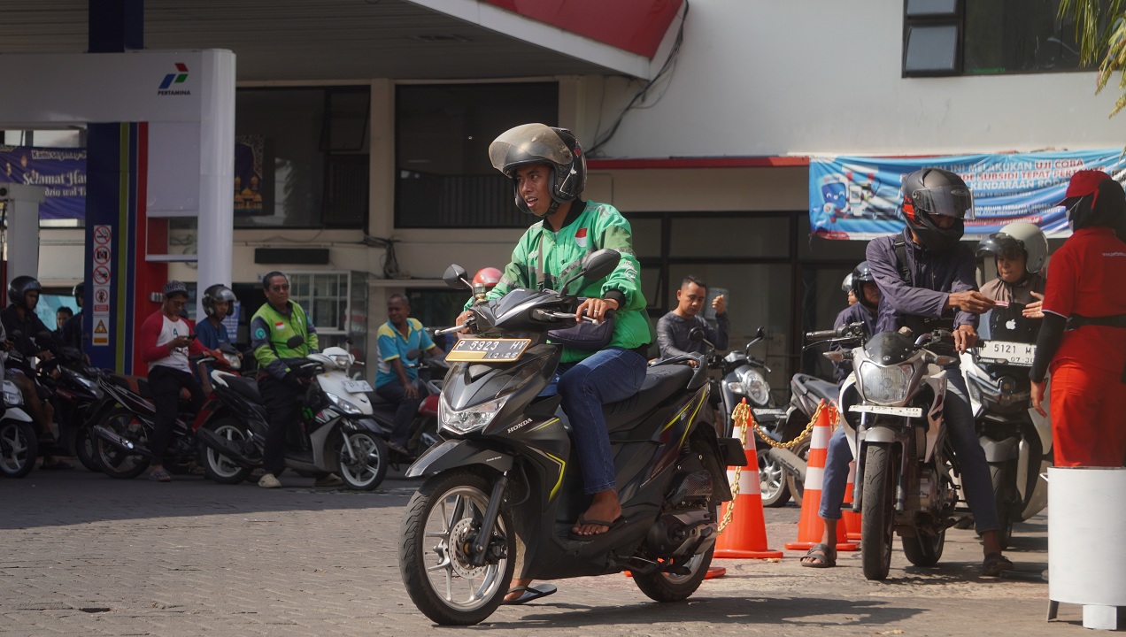SEMRINGAH: Seorang pengemudi ojol akhirnya dapat tersenyum lebar usai mendapat giliran pengisian BBM setelah antre berjam-jam di SPBU Jalan Gajah Mada, kemarin (27/6/2025).