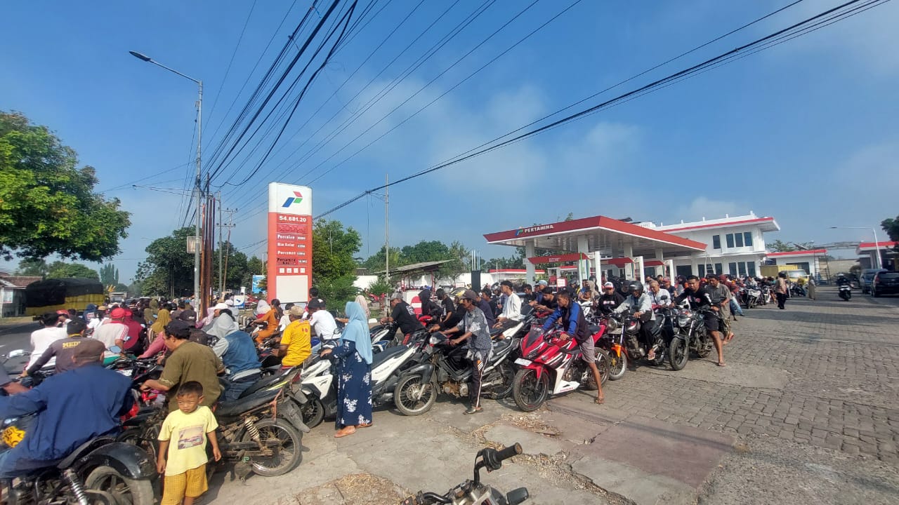 ANTRI BBM: Ratusan pengendara sepeda motor yang antri BBM di SPBU Jenggawah hingga mengelilingi pom dan ke jalan raya jurusan Mangli- Ambulu pada Minggu (27/7). (JUMAI/RJ)