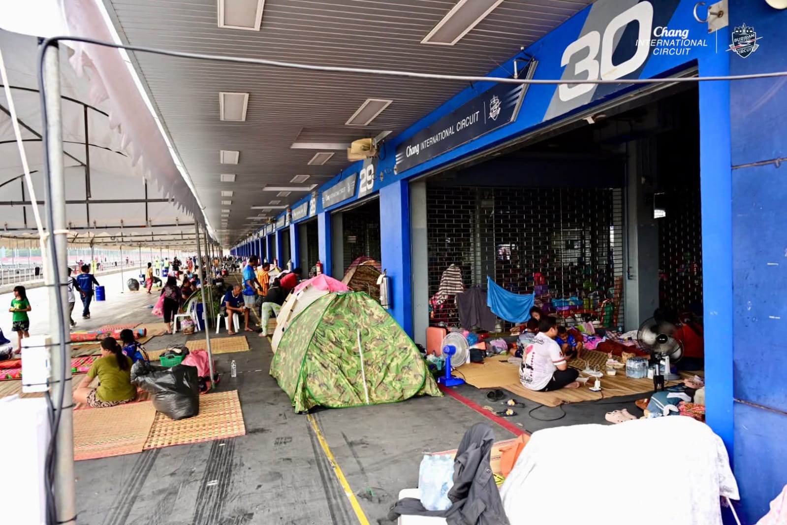 Ratusan tenda tampak memenuhi area pit lane Sirkuit Buriram, Thailand. Dihuni oleh warga sipil yang mengungsi akibat pertempuran di wilayah perbatasan kedua negara.