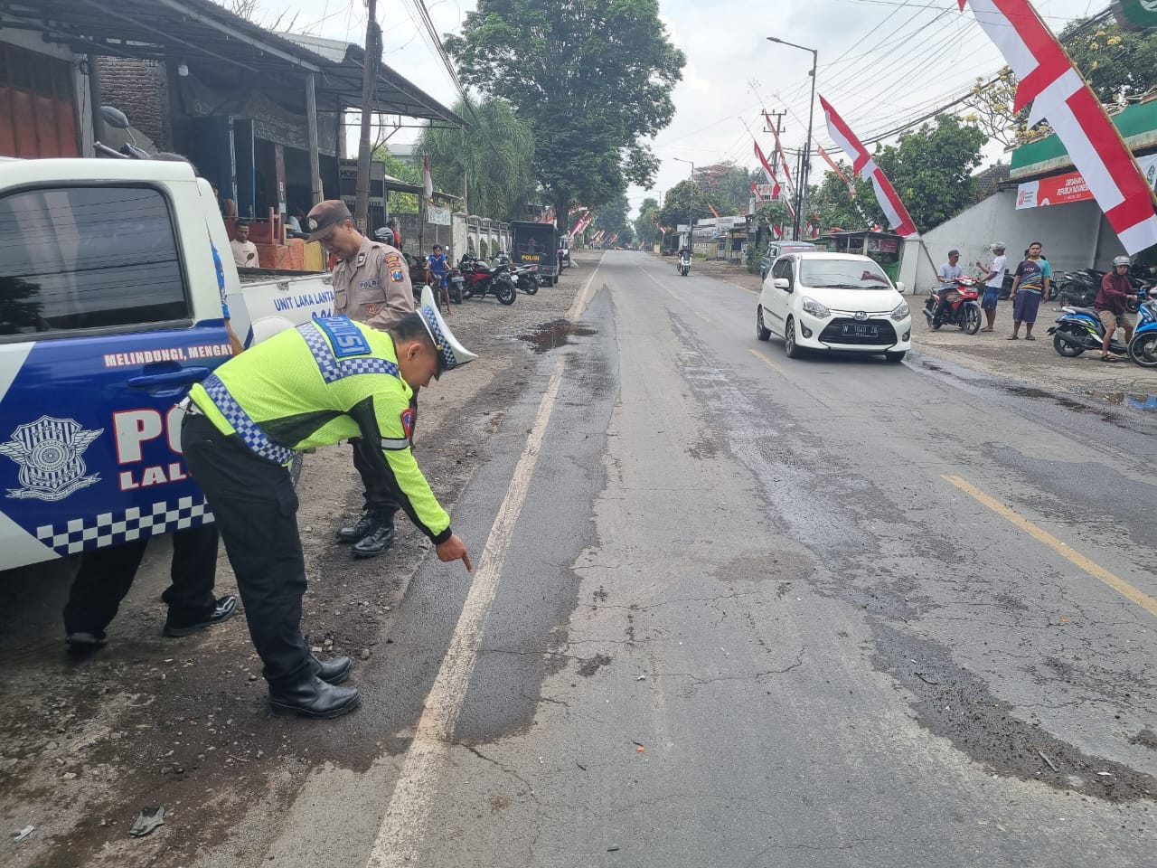 DATANGI LOKASI: Anggota Laka Satlantas Polres Jember saat mendatangi lokasi kecelakaan di jalan raya nasional Dusun Lamparan, Desa Kertosari, Kecamatan Pakusari Minggu (10/8),