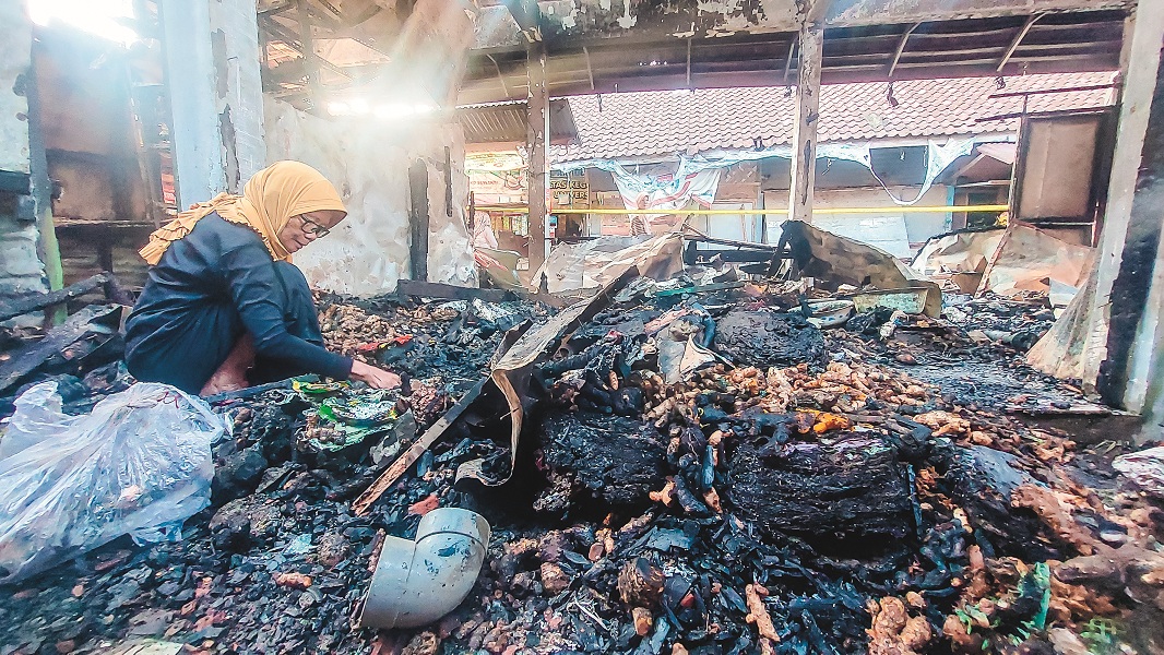 AMBIL SISA-SISA: Nenek Jumaiya, pedagang bumbu dapur yang lapaknya ludes dilahap api mencari sisa barang yang layak pakai setelah terbakar.