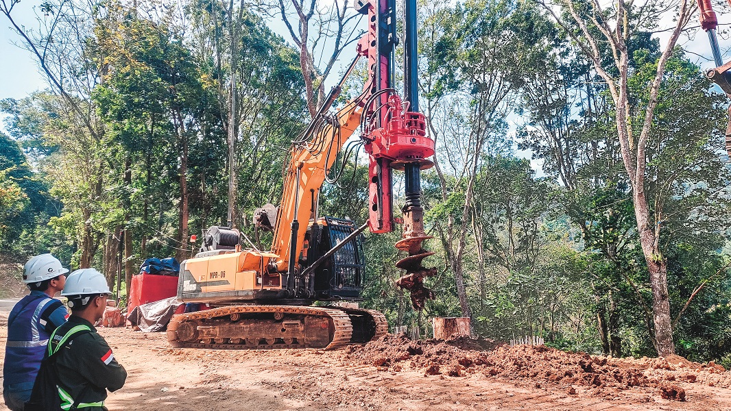 IKUT DIKERJAKAN: Alat berat jenis bore pile mengebor jalan yang ambrol di KM 37.600, Dusun Gumitir, Desa Sidomulyo, Kecamatan Silo, Kamis (14/8).