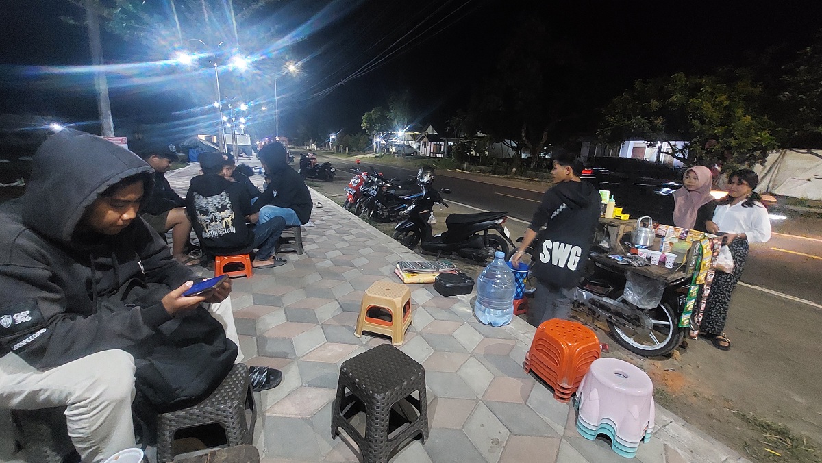 BIKIN BETAH: Trotoar Lapangan Desa Garahan, Kecamatan Silo, menjadi tempat tongkrongan baru setelah trotoarnya di renovasi hingga menjadi tempat lesehan.