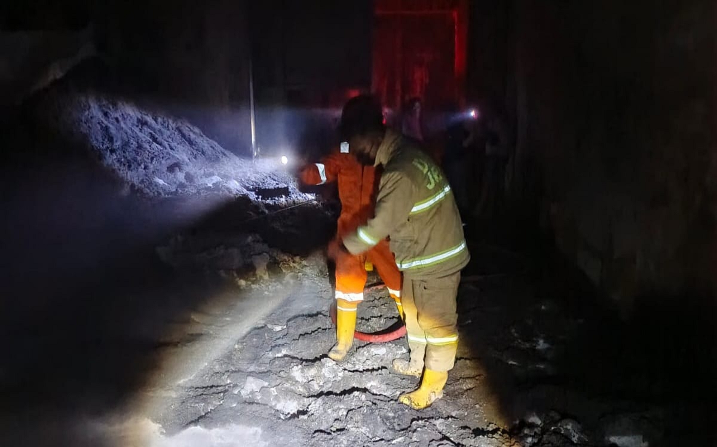 LAKUKAN PENDINGINAN: Petugas damkar Regu B melakukan pendinginan di lokasi kebakaran sekam, di gudang milik Hartono, warga Dusun Krajan II, Desa/Kecamatan Jombang.