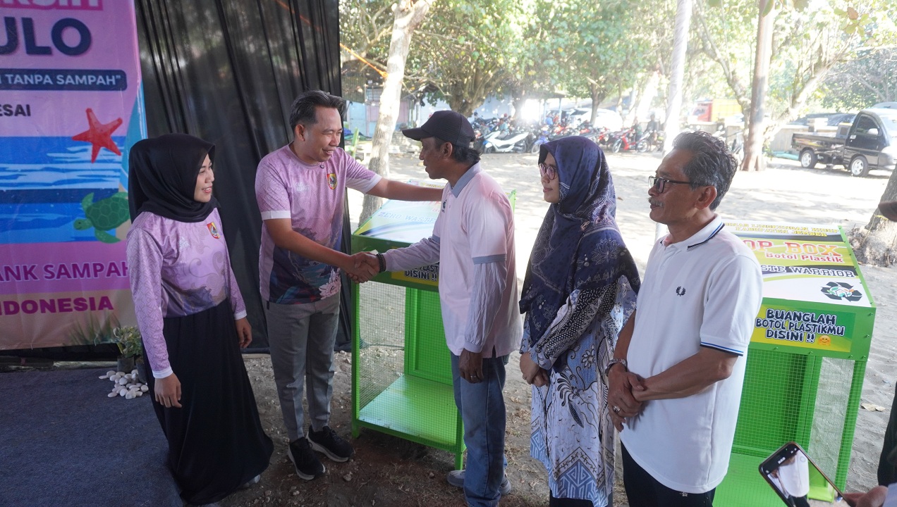MULAI DISERIUSI: Bupati Fawait saat simbolis menyalurkan bantuan tempat sampah plastik ke sejumlah Pokdarwis Pantai Watu Ulo Ambulu, akhir Juni lalu.