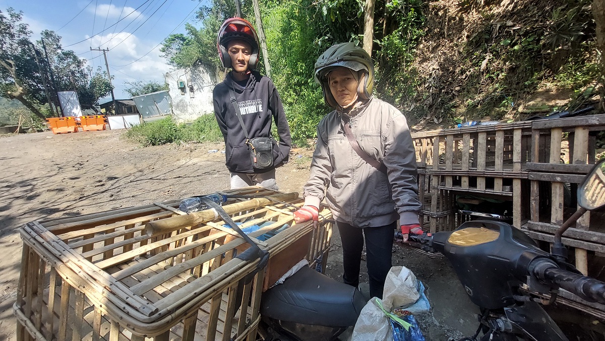 TETAP JUALAN: Susilowati bersama anaknya, Alfin Aerlangga, asal Desa Pocangan, Kecamatan Sukowono, tetap jualan ayam dan melintas di jalan alternatif Gumitir untuk menuju Banyuwangi.