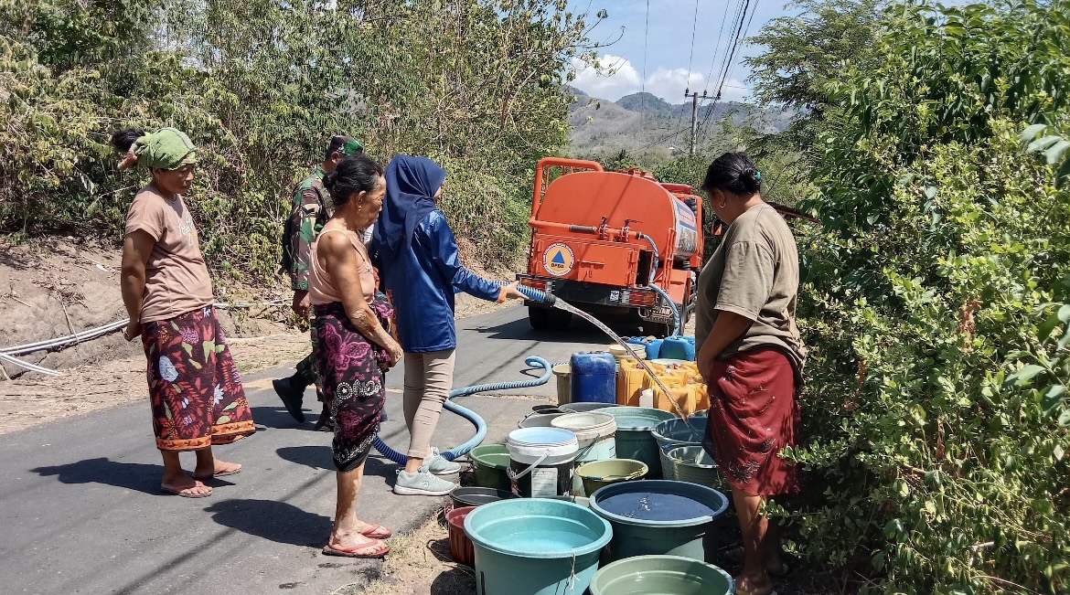 MENGANTRE: Warga terdampak kekeringan saat mendapatkan bantuan air bersih, kemarin (21/8).(FAQIH HUMAINI/RADAR IJEN)