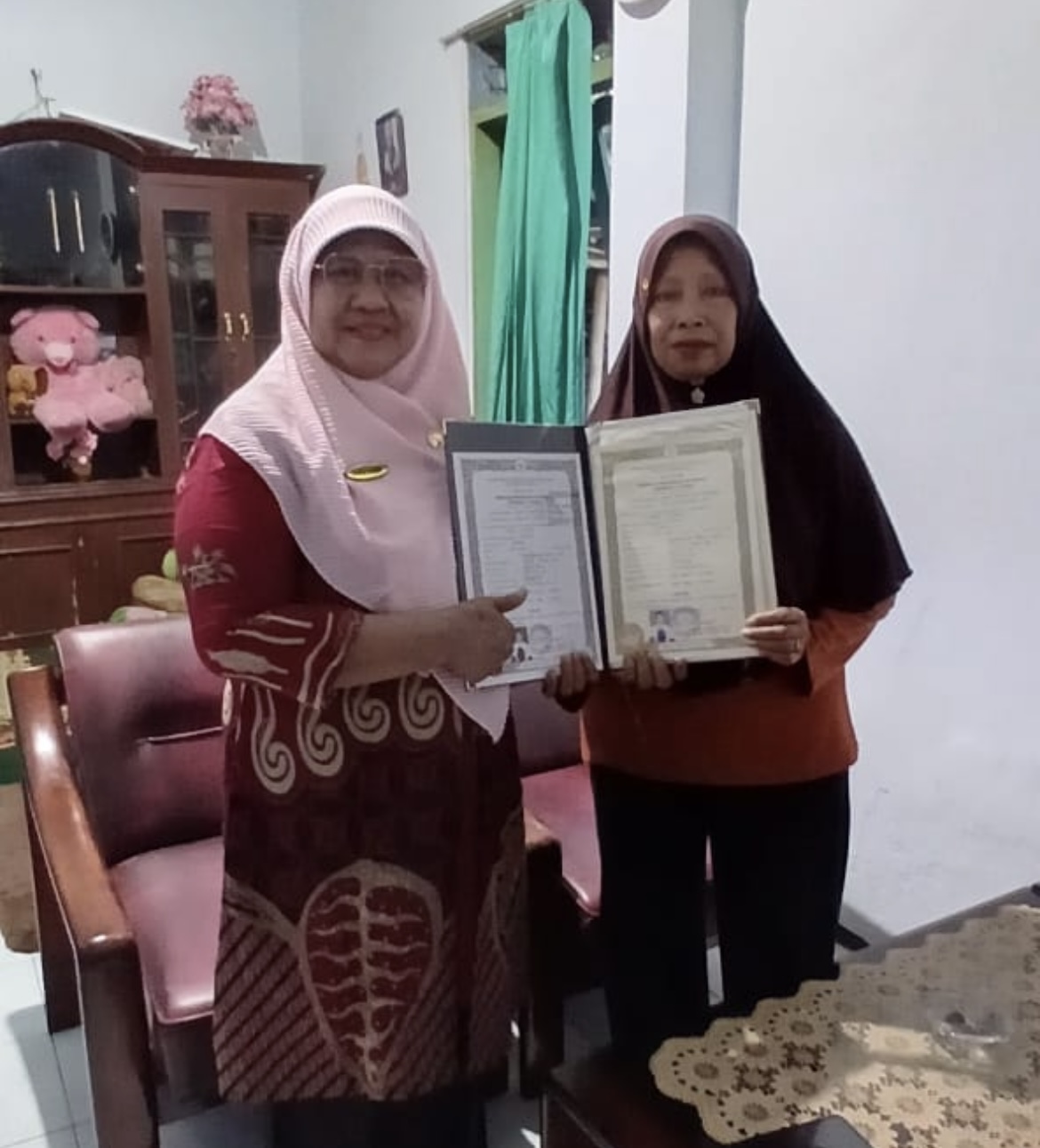 SERAHKAN: Kepala Sekolah Menengah Kejuruan (SMK) Negeri 1 Lumajang, Susie Harini, M.Pd menyerahkan ijazah ke rumah siswa. (WIWIT FOR RAME)