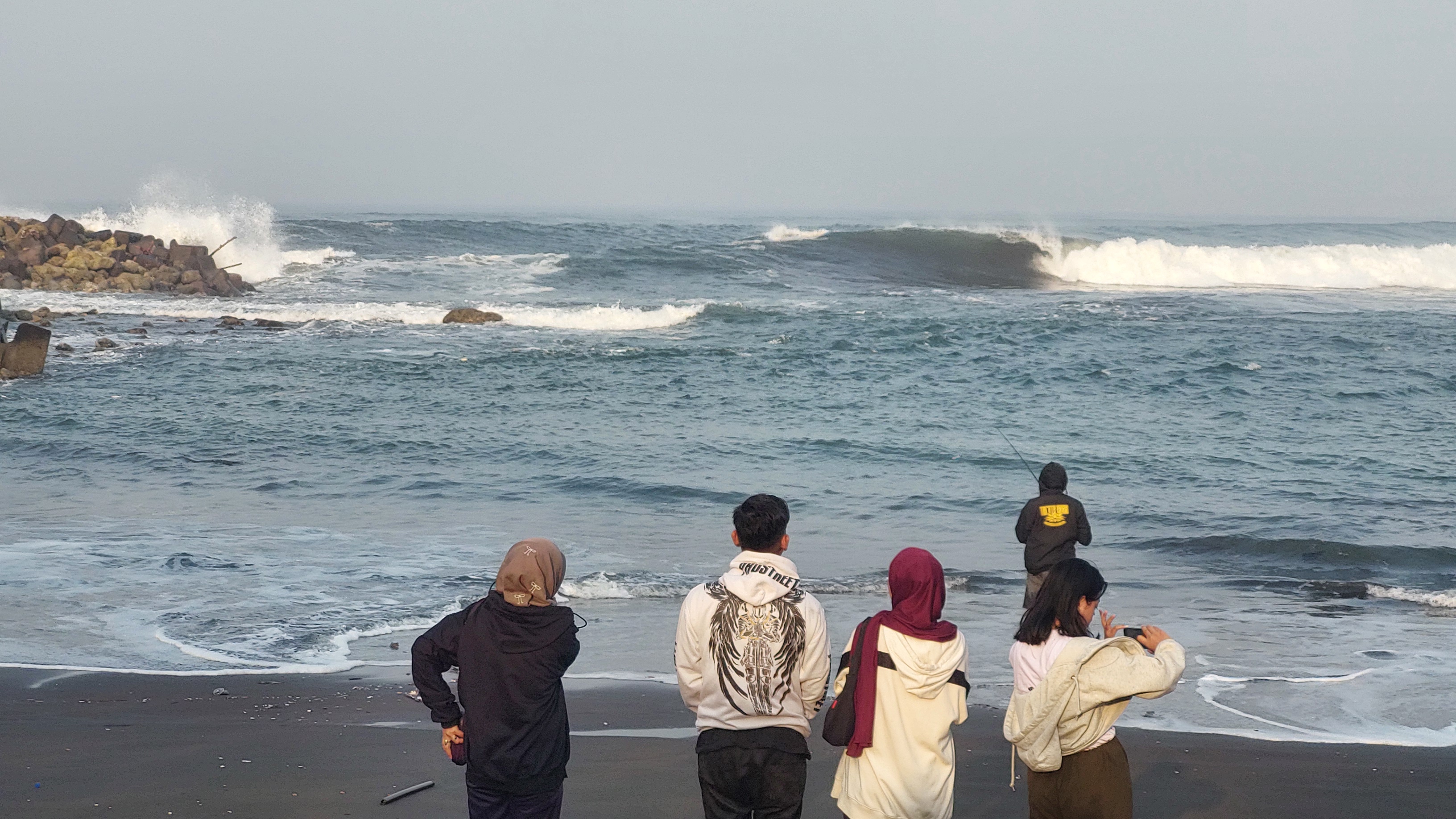 KELUARGA MENUNGGU: Disaat ombak besar banyak keluarga nelayan yang menunggu disekitar Plawangan Pancer Puger, Desa Puger Kulon, Kecamatan Puger Minggu (24/8)