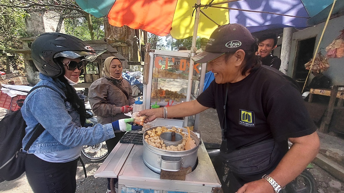 Samsul, warga Dusun Barurejo, Desa Kalibaru Manis, Kecamatan Kalibaru, memanfaatkan penutupan jalan nasional dengan berjualan cilok di pintu masuk jalan alternatif, Desa Sidomulyo, Kecamatan Silo.