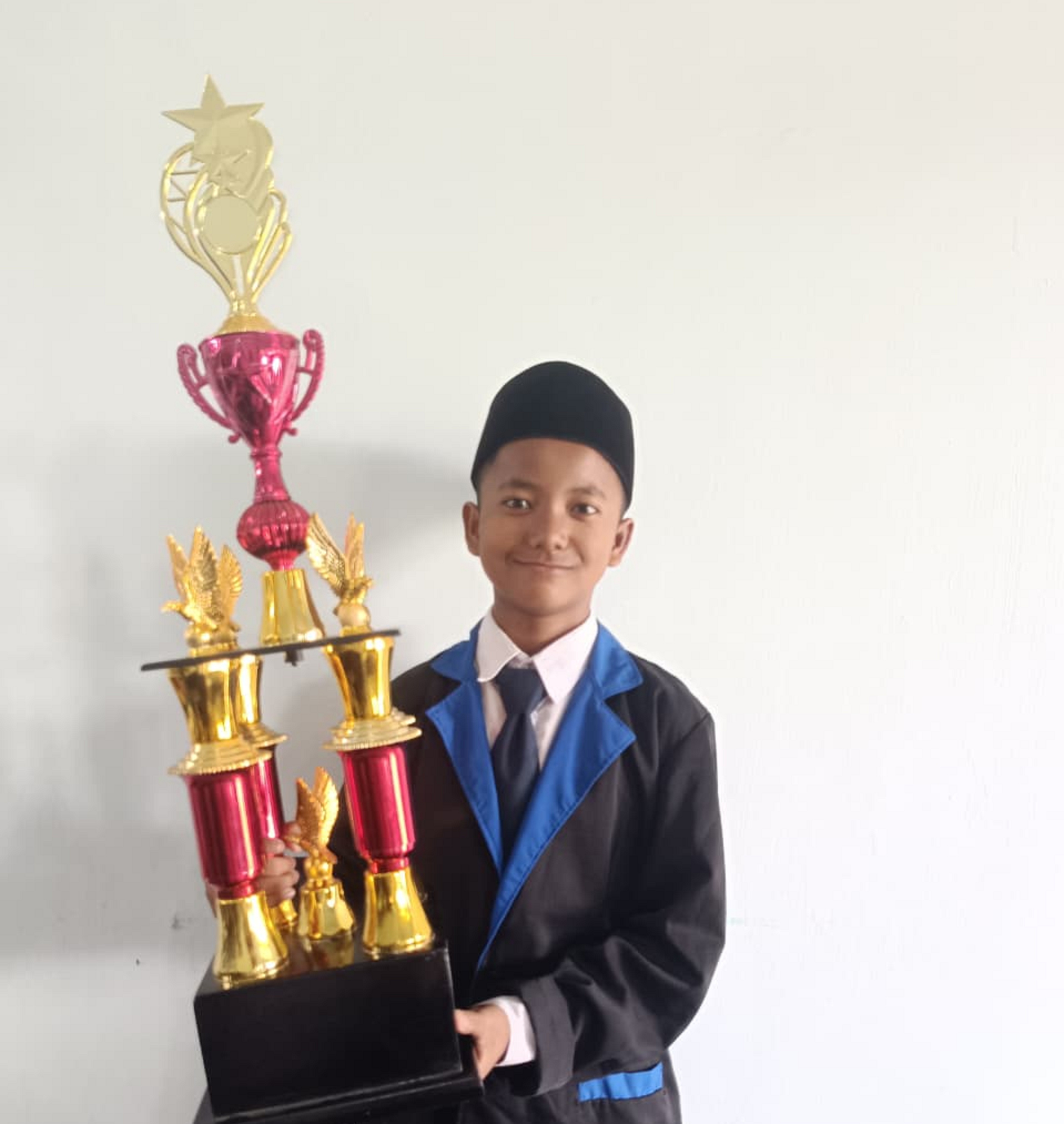MEMBANGGAKAN: Afghani Gilang Hidayatullah Farid, siswa SMP Nuris Jember, berhasil angkat trofi juara 3 OSNK, hingga mengantarkannya melaju ke olimpiade tingkat provinsi.