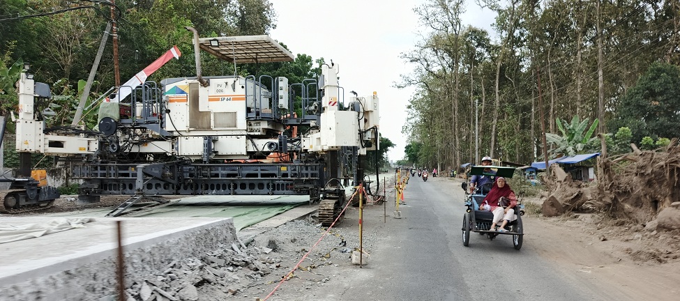 SISTEM BUKA TUTUP: Jalan penghubung Rambipuji-Puger, di simpang tiga Kaliputih ke arah selatan, kini masih diperbaiki. Terlihat sejumlah kendaraan roda empat harus bergantian melintas.