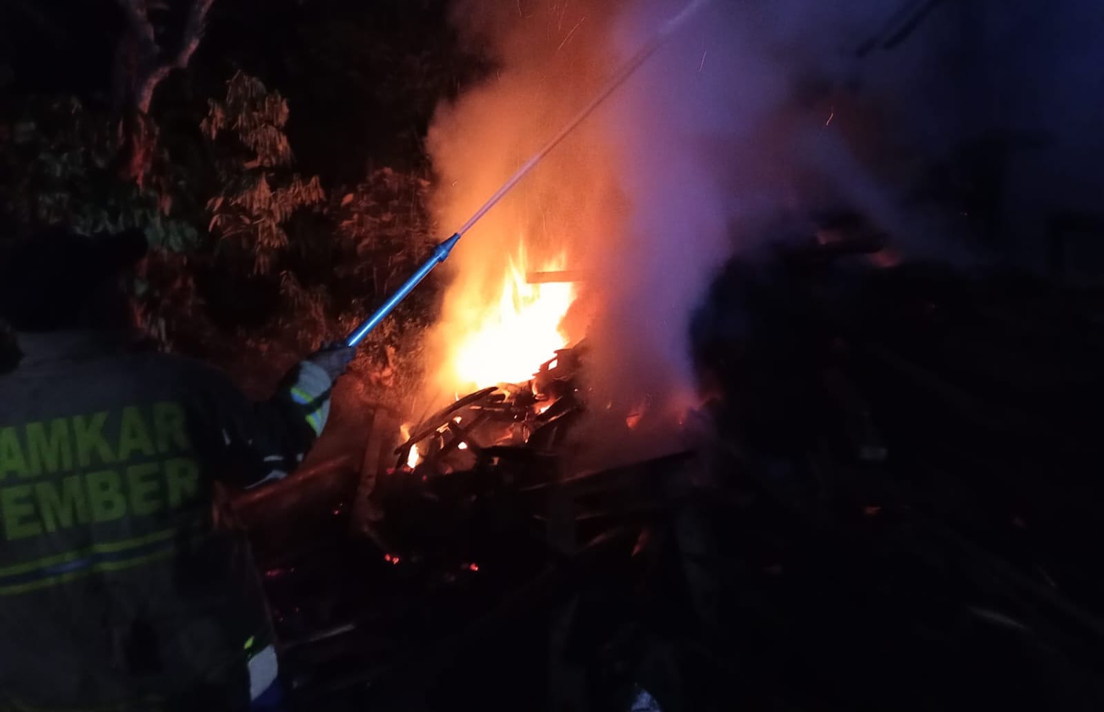 PADAMKAN API: Petugas Damkar dari Posko Kalisat saat mendatangi rumah korban untuk melakuka pemadaman.