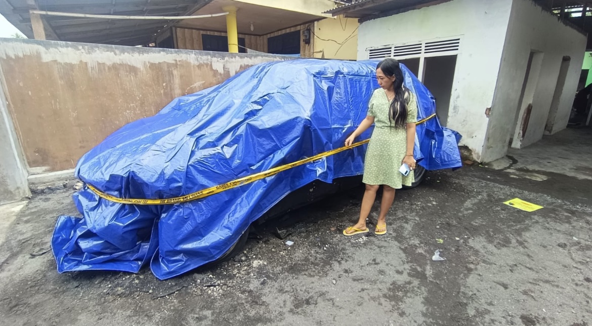 CEK: Korban saat melihat mobil miliknya yang diduga dibakar oleh orang tidak dikenal, kemarin.(ATIEQSON MAR IQBAL/RAME)