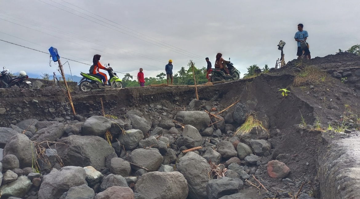 TERKIKIS: Sejumlah warga nekat melintasi akses jalan yang mulai terkikis di kawasan daerah aliran sungai (DAS) Semeru, kemarin.(ATIEQSON MAR IQBAL/RAME)