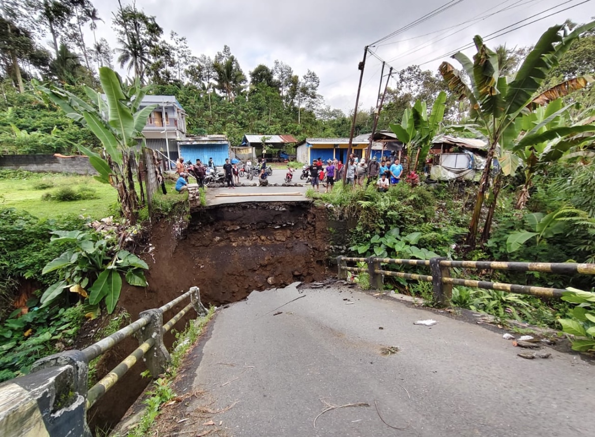 TERPUTUS: Sejumlah warga saat melihat akses jalan jembatan yang terputus di Desa Kandangan, Kecamatan Senduro, kemarin. (ATIEQSON MAR IQBAL/RAME)