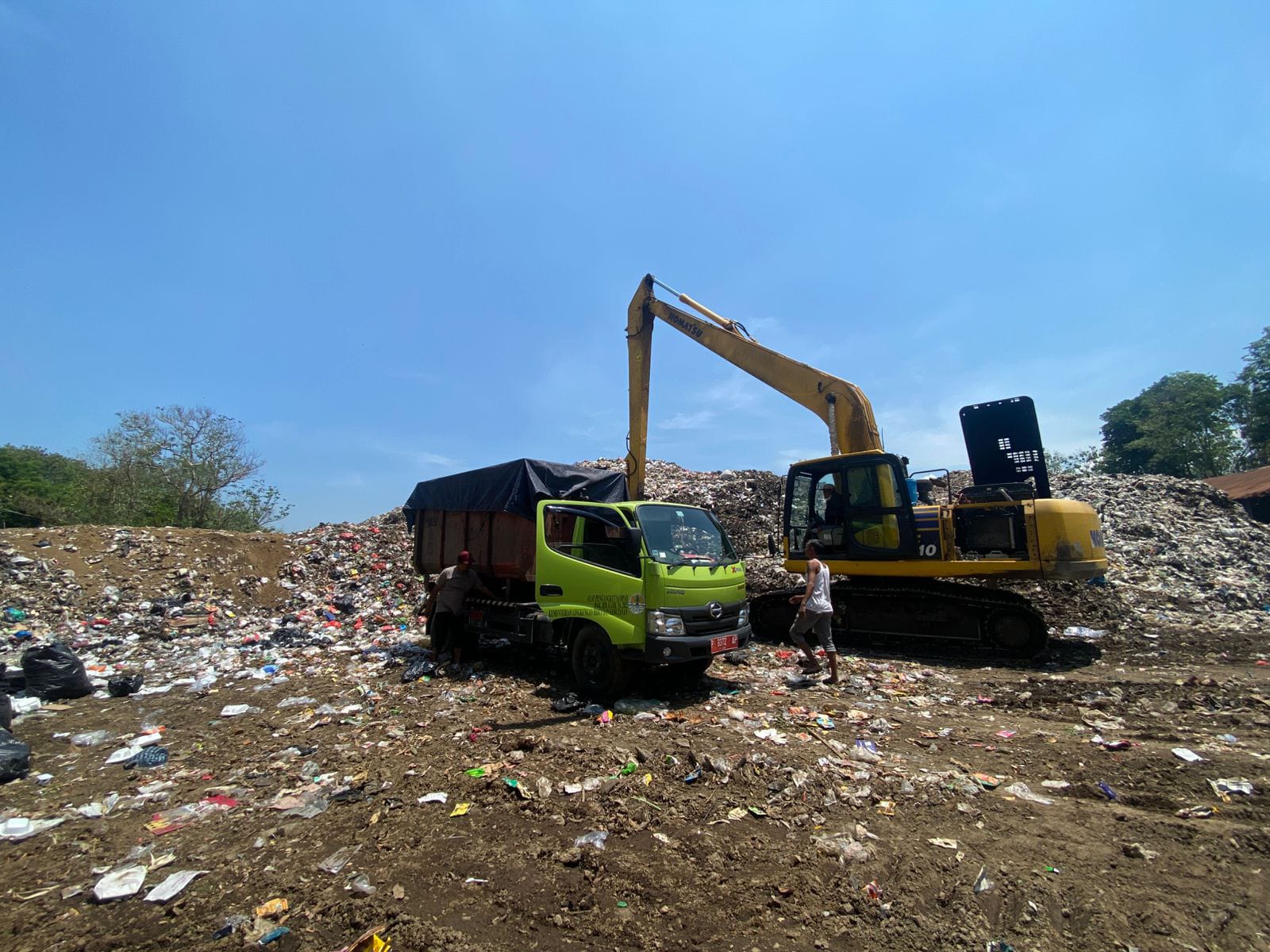 MENGGUNUNG: Sejumlah pekerja di TPA Paguan yang terus mengurai sampah dengan dump truk serta alat berat. (ILHAM/RJ)