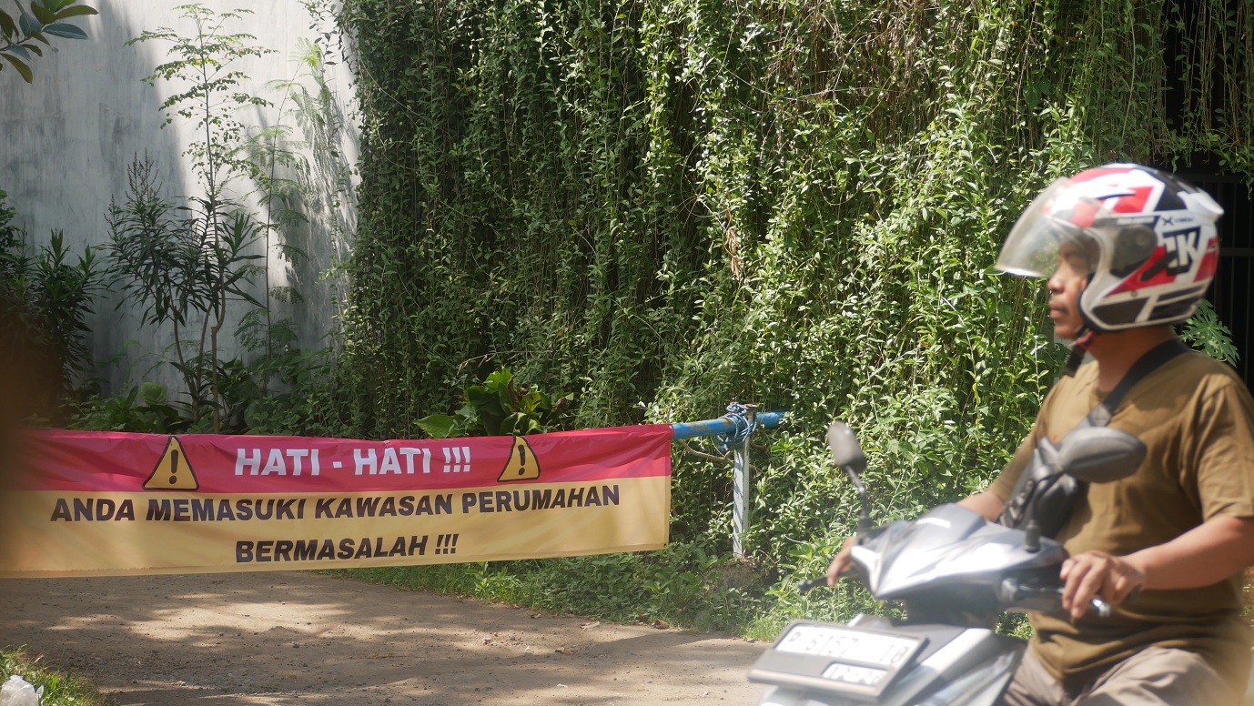 BAGAIMANA INI: Banner protes terpasang di pintu masuk Perumahan Grand Permata Indah (GPI) Kelurahan/Kecamatan Sumbersari Jember.