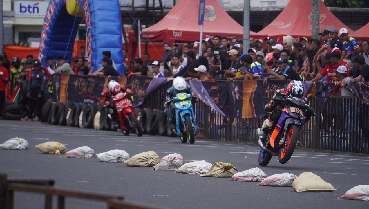 PACU ADRENALIN: Jalan Sudarman atau depan Kantor Pemkab Jember yang berubah menjadi sirkuit balap motor saat pembukaan Jember Road Race Championship 2025, Minggu (21/9).