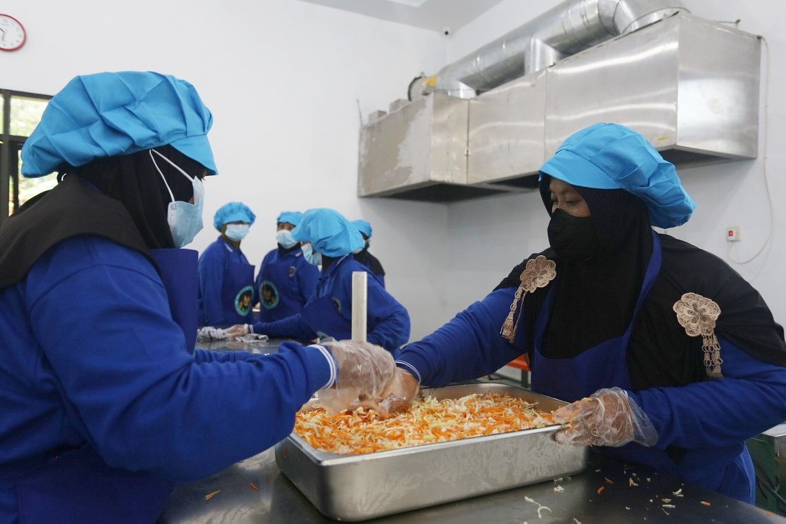 FOKUS: Sejumlah orang di dapur MBG Wonoasri Kecamatan Tempurejo menyiapkan produksi makanan saji, kemarin (24/9).