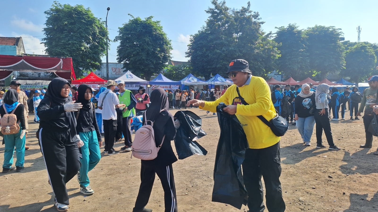 SADAR KEBERSIHAN: Sejumlah siswa bersama para tokoh tampak bersemangat berjibaku dalam aksi bersih-bersih di Alun-Alun Ambulu, Minggu (21/9).