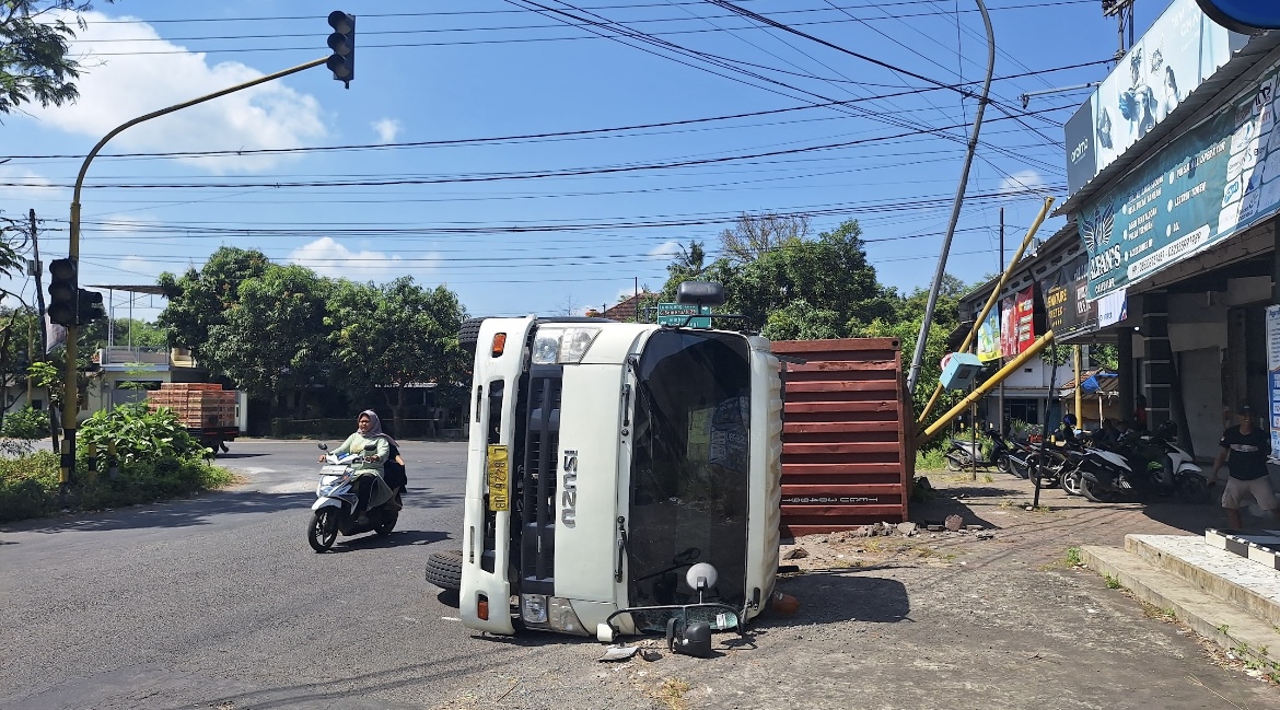 GULING: Kondisi truk muatan beras terguling dikawasan Jalan Raya Kedungjajang, kemarin pagi.(AINUN MUSYAROF)