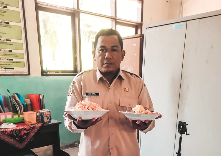 MAKANAN BASI: Fadli, guru SDN Bintoro 05, Kelurahan Bintoro, Kecamatan Patrang menunjukkan makanan basi yang diberikan kepada siswanya.